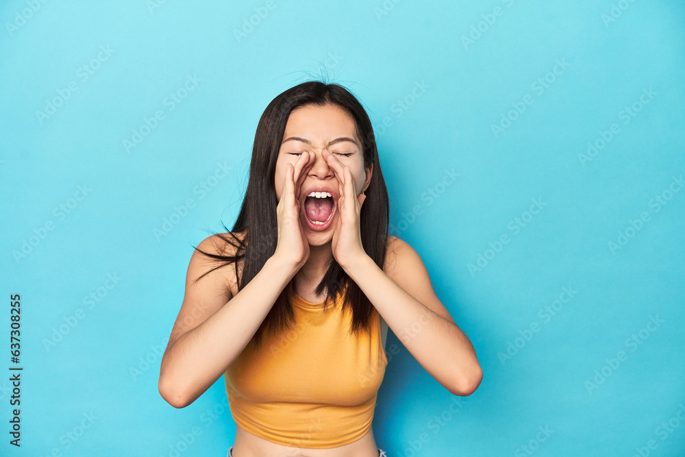 Asian woman in summer yellow top, studio setup, shouting excited to front. Asian woman in summer yellow top, studio setup, shouting excited to front.