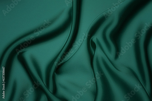 Texture, background, pattern. Texture of green silk fabric. Beautiful emerald green soft silk fabric.