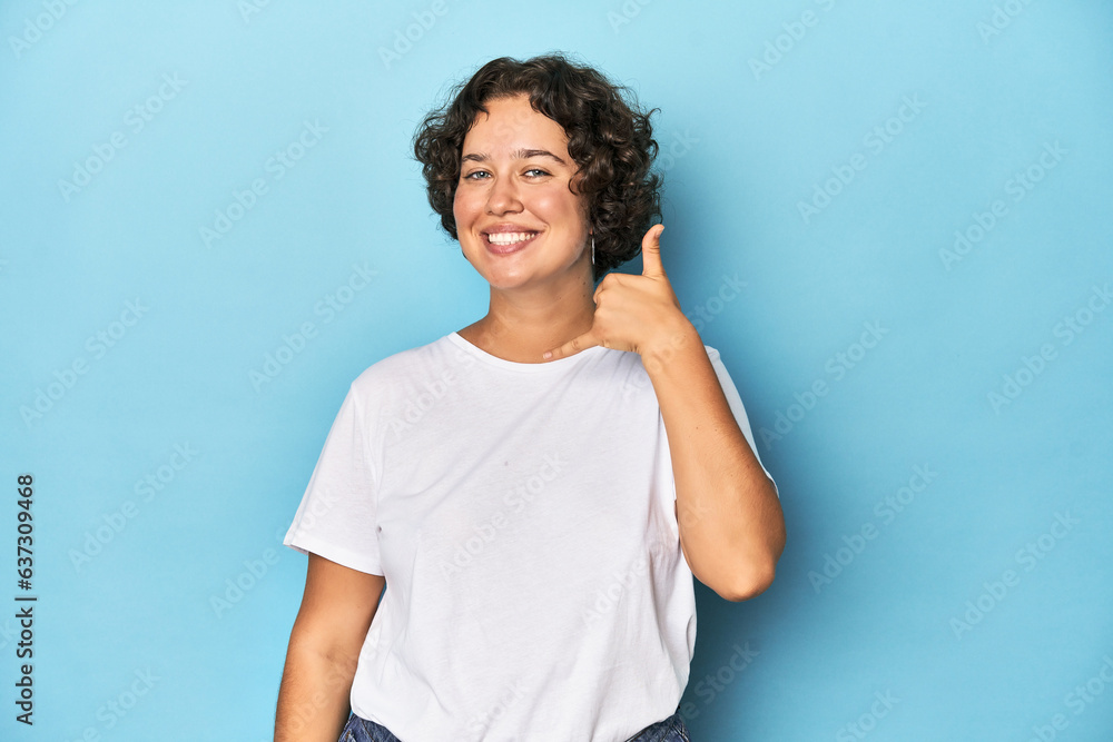 Young Caucasian woman with short hair showing a mobile phone call gesture with fingers. Young Caucasian woman with short hair showing a mobile phone call gesture with fingers.