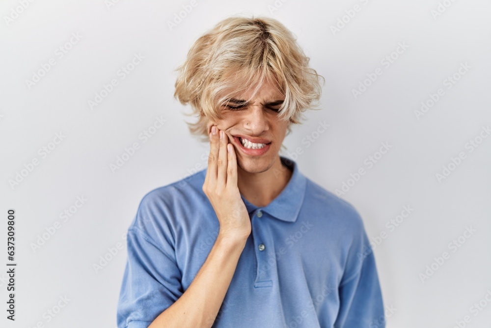 Young modern man standing over isolated background touching mouth with hand with painful expression because of toothache or dental illness on teeth. dentist