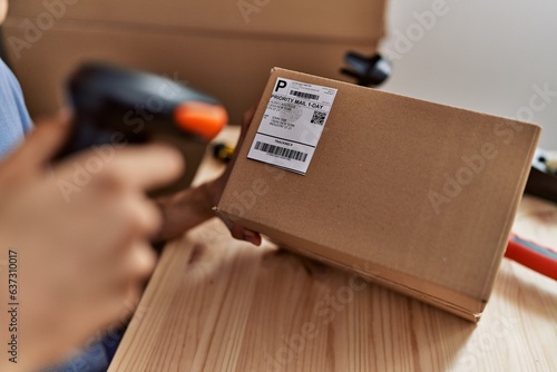 Young blond man ecommerce business worker scanning package at office