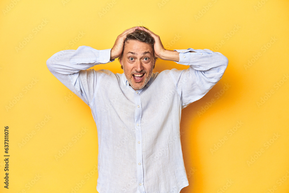 Middle-aged man posing on a yellow backdrop screaming, very excited, passionate, satisfied with something. Middle-aged man posing on a yellow backdrop screaming, very excited, passionate, satisfied with something.