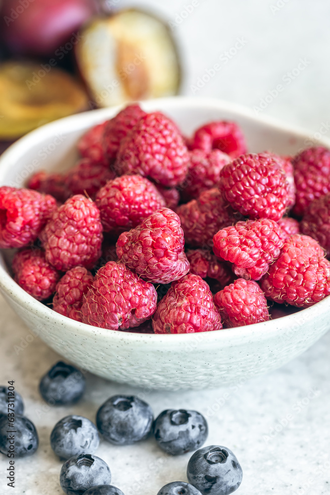 Bowl with raspberries on the kitchen table, close-up. Bowl with raspberries on the kitchen table, close-up.