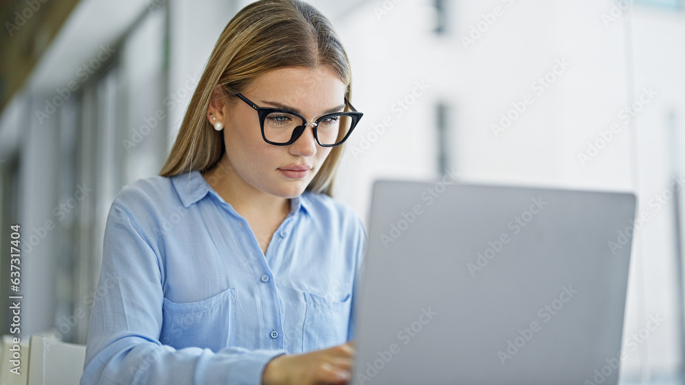 Young blonde woman business worker using laptop working at office Young blonde woman business worker using laptop working at office