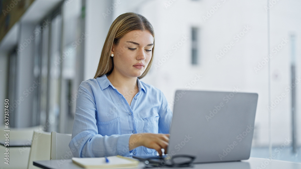 Young blonde woman business worker using laptop working at office Young blonde woman business worker using laptop working at office