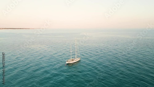 boat sailing in calm open sea at sunset - Italy, Salento, Marina di Lizzano, Taranto, Puglia photo