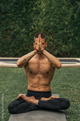 man doing yoga meditation in a park