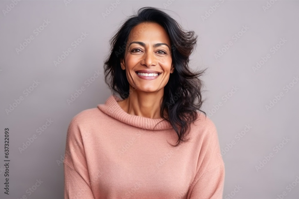 Medium shot portrait of an Indian woman in her 40s in a colorful background Medium shot portrait of an Indian woman in her 40s in a colorful background