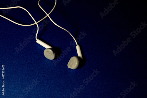Wired Stereo Ear Buds Isolated on a Blue Table Cloth
