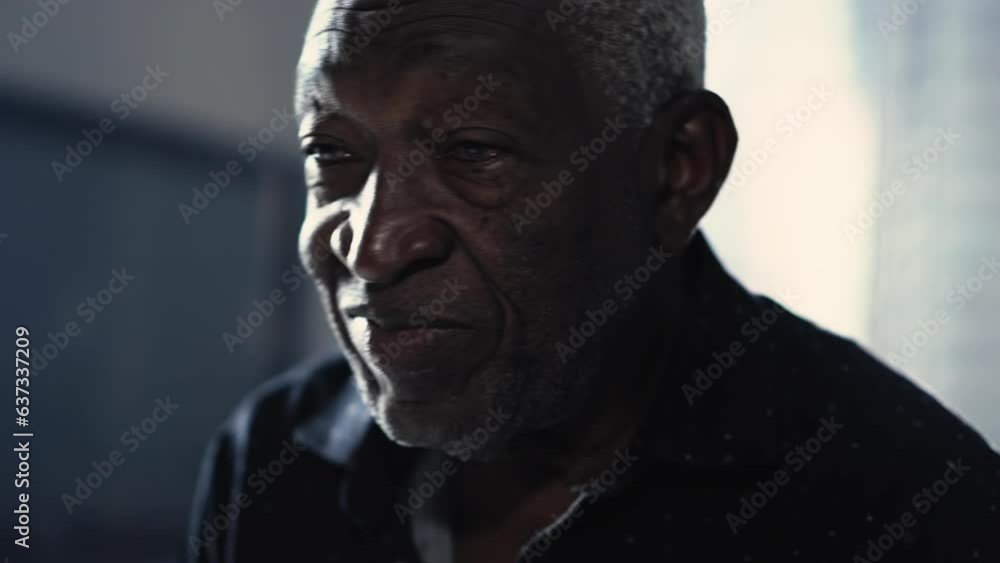 One contemplative senior black man sitting quietly inside room thinking. Thoughtful African American person close-up face in room contemplating life One contemplative senior black man sitting quietly inside room thinking. Thoughtful African American person close-up face in room contemplating life
