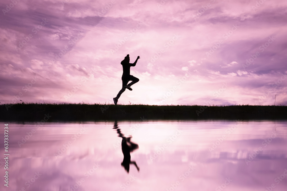 man jumping over a pond with a sunset  background