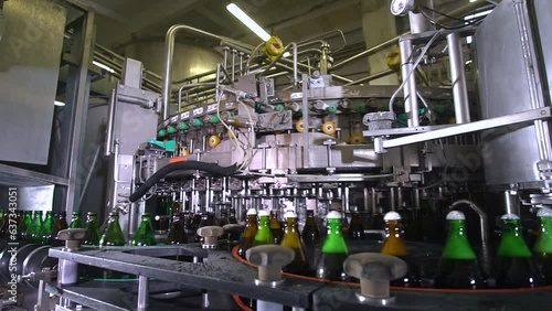 Conveyor with glass bottles at the plant for the production of various beers, soda, water or other alcoholic or soft drinks. photo