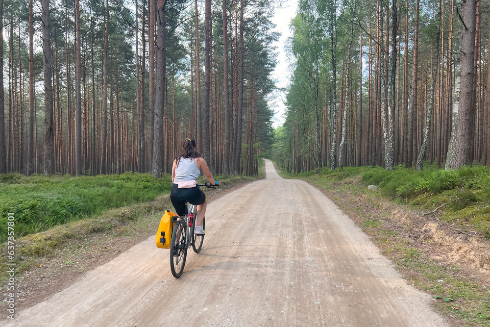Woodland Adventure. Girl Cycling Through Nature's Beauty. Concept of recreation in nature. Young Woman's Bicycle Adventure in the Woods.