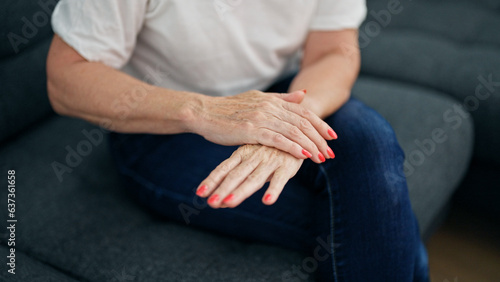 Middle age woman applying lotion on hand home