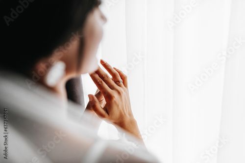 A gold ring with a diamond on the finger of the bride. Morning of the bride. Wedding day. Black and white photo photo