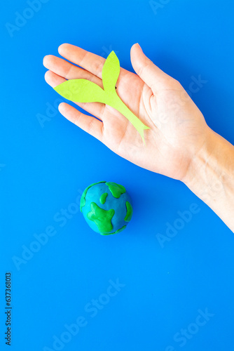 Clay globe planet Earth with paper green plant. Safe our planet concept