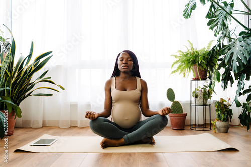 Black pregnant woman meditating during yoga practice