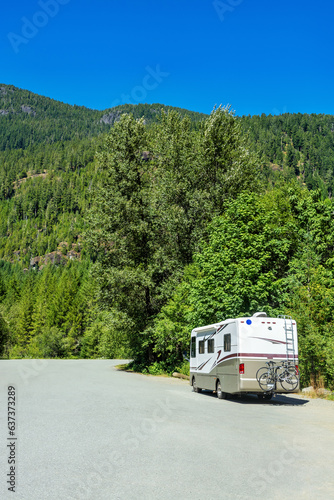 Luxury motorhome with bykes attached to the rack on an asphalt road photo