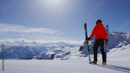 Skier posing on a sunny day with epic mountains in the background