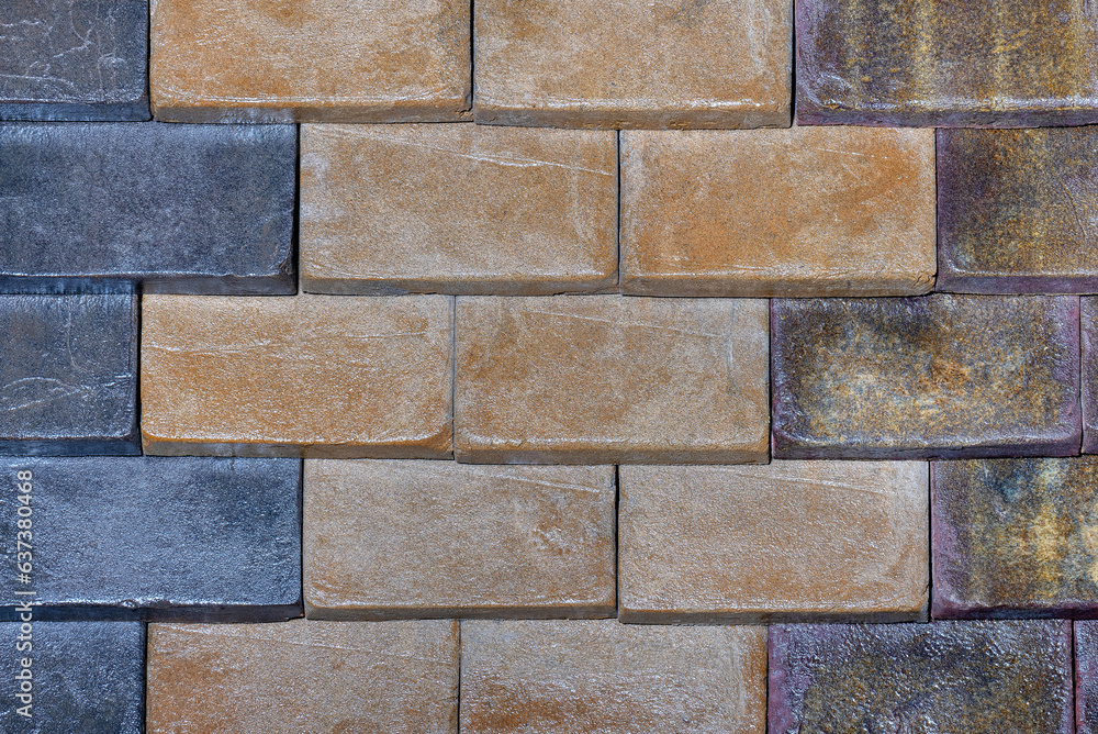 Obraz premium The stone wall is lined with decorative rectangular blocks with different colors.