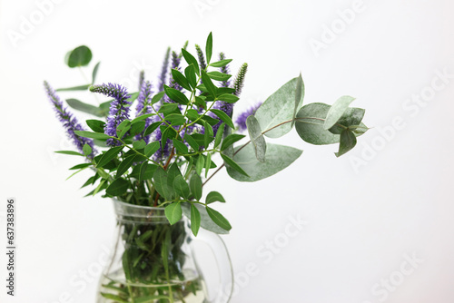 a bouquet of wild flowers in a clear glass vase on a white background