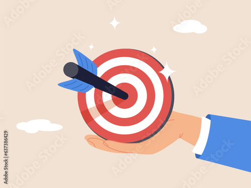 Goal or target. Purpose or objective. Focus and concentration to achieve success, aiming at target bullseye, accuracy, challenge and aspiration, businessman hand hold target with arrow hit bullseye.