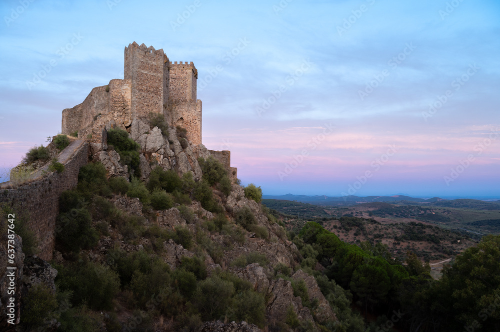 A Pink and Purple Sunset Sky over a Castle on a Hilltop