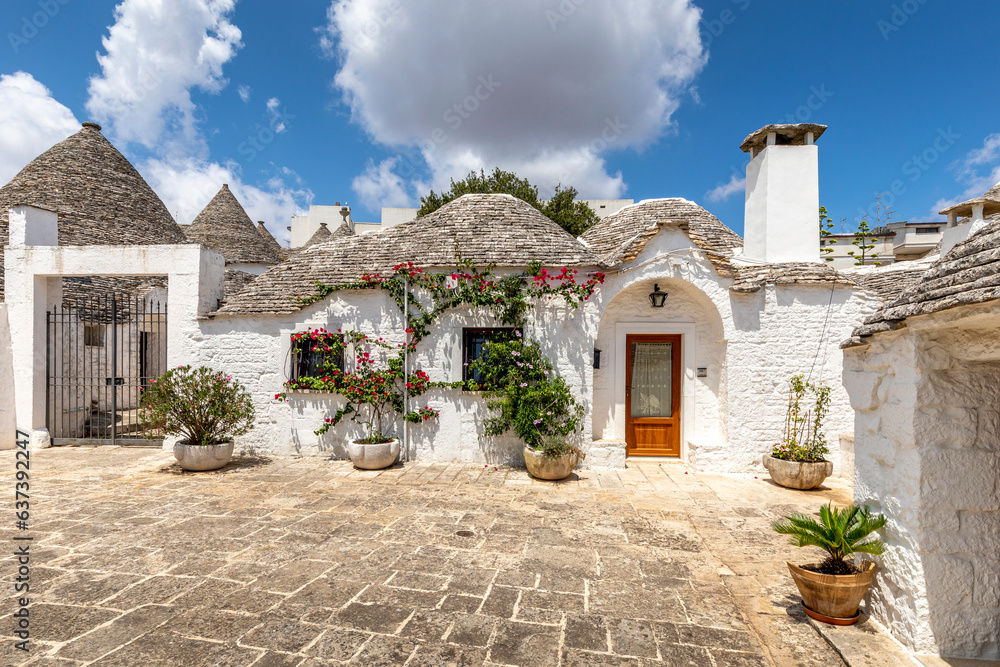 Alberobello, Italy - July 21, 2021: The Trulli of Alberobello in Apulia in Italy. Typical houses with dry stone walls and conical roofs