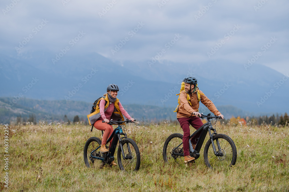 Happy couple at bicycles, in the middle of autumn nature. Concept of a healthy lifestyle. Happy couple at bicycles, in the middle of autumn nature. Concept of a healthy lifestyle.