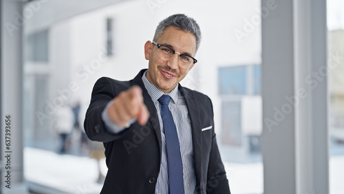 Young hispanic man business worker smiling confident pointing to camera at office