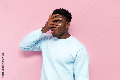 Billede på lærred shocked african man in blue sweater covers his face with his hands hiding and pe
