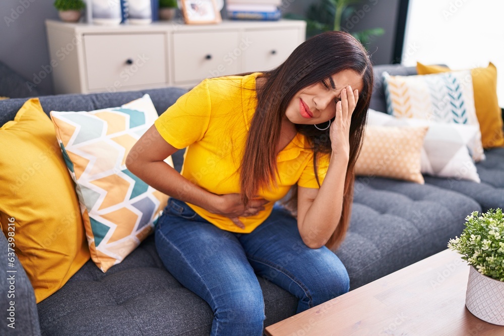 Young beautiful arab woman suffering for head and stomach ache at home Young beautiful arab woman suffering for head and stomach ache at home