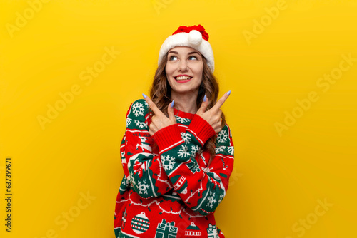 unsure girl in christmas sweater and santa claus hat chooses from two options on yellow isolated background