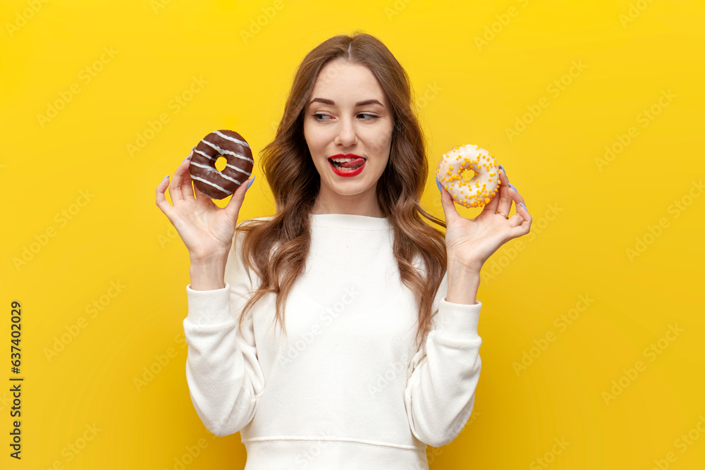 young cute girl with sweet donuts thinks and chooses on yellow isolated background, woman with pastry imagines