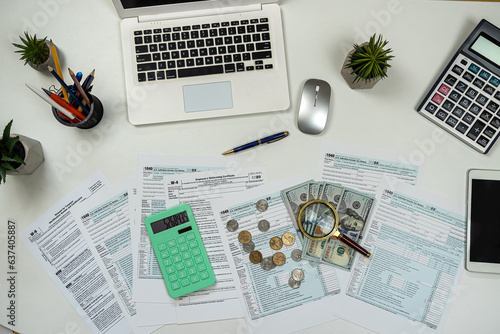 Office workplace tax 1040 form with caluclator and pen, us dollar bills and coin on desk photo