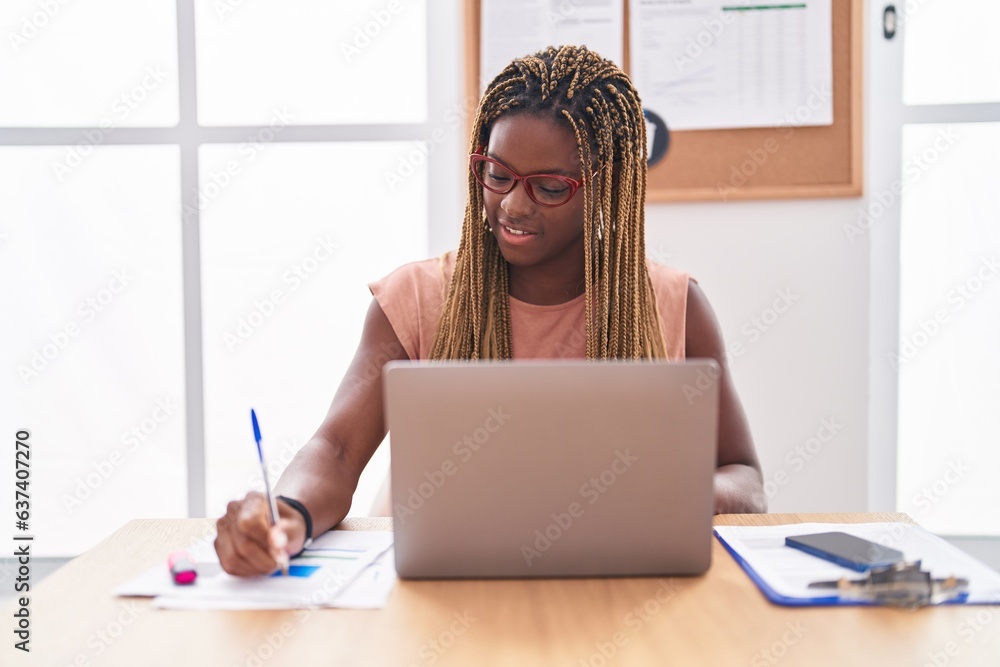 Obraz premium African american woman business worker using laptop writing on document at office