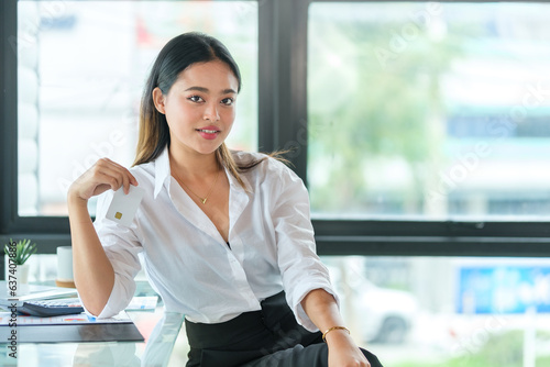 Free Download Portrait of millennial businesswoman in white shirt sitting at desk and looking at camera. - GFXLoad