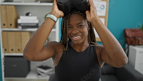 Fototapeta Naklejka Na Ścianę i Meble -  African american woman business worker wearing virtual reality glasses smiling at the office