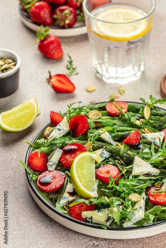 Fototapeta Naklejka Na Ścianę i Meble -  strawberry salad with asparagus, arugula, blue cheese and seeds. Delicious breakfast or snack, Clean eating, dieting, vegan food concept. top view