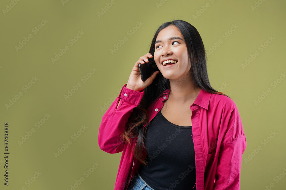 Photo of young asian woman talking on phone and smiling, standing with smartphone against on green pastel background. Photo of young asian woman talking on phone and smiling, standing with smartphone against on green pastel background.