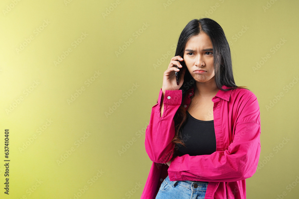 Expression of sad and talks on cell phone, isolated on green pastel background. Expression of sad and talks on cell phone, isolated on green pastel background.