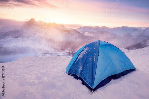 Tent camping on the peak with sunrise over mountain on winter