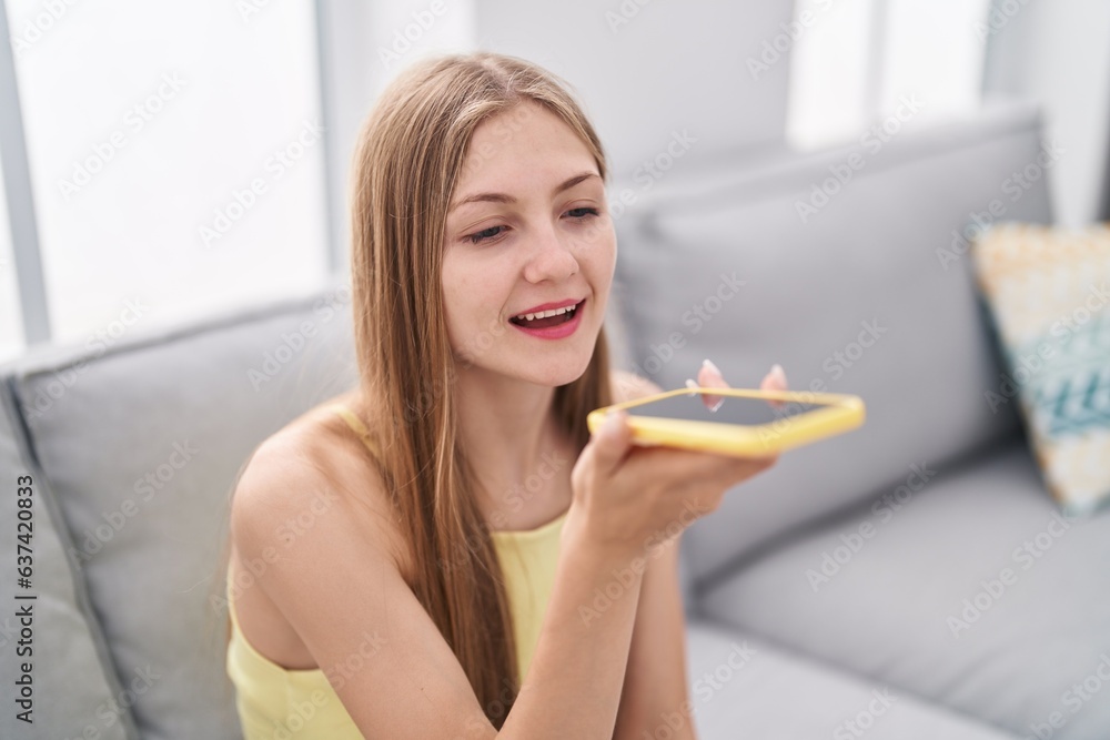 Young caucasian woman talking on the smartphone sitting on sofa at home Young caucasian woman talking on the smartphone sitting on sofa at home