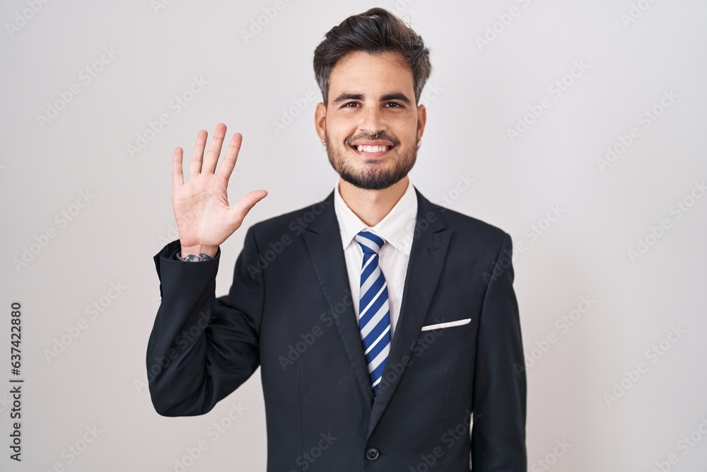 Young hispanic man with tattoos wearing business suit and tie showing and pointing up with fingers number five while smiling confident and happy. Young hispanic man with tattoos wearing business suit and tie showing and pointing up with fingers number five while smiling confident and happy.