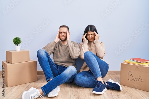 Young couple moving to a new home with hand on head, headache because stress. suffering migraine. © Krakenimages.com