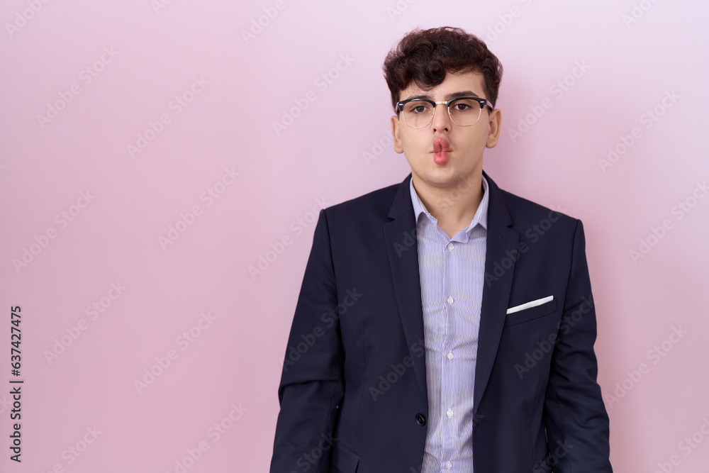 Fototapeta premium Young non binary man with beard wearing suit and tie making fish face with lips, crazy and comical gesture. funny expression.