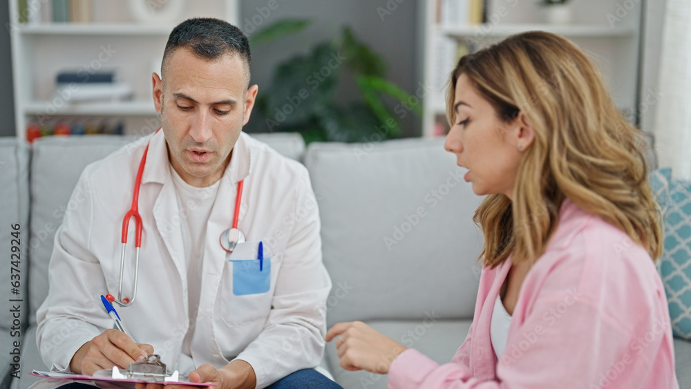 Man and woman doctor and patient writing medical report at the clinic Man and woman doctor and patient writing medical report at the clinic