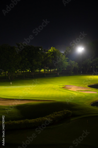Beautiful dark night view of the golf course, Bunkers sand and green grass, garden background In the light of the spotlight underexposure view.