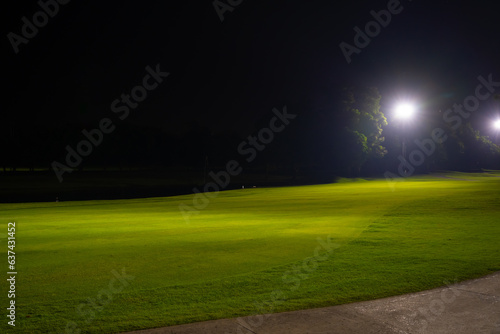 Beautiful dark night view of the golf course, Bunkers sand and green grass, garden background In the light of the spotlight underexposure view.