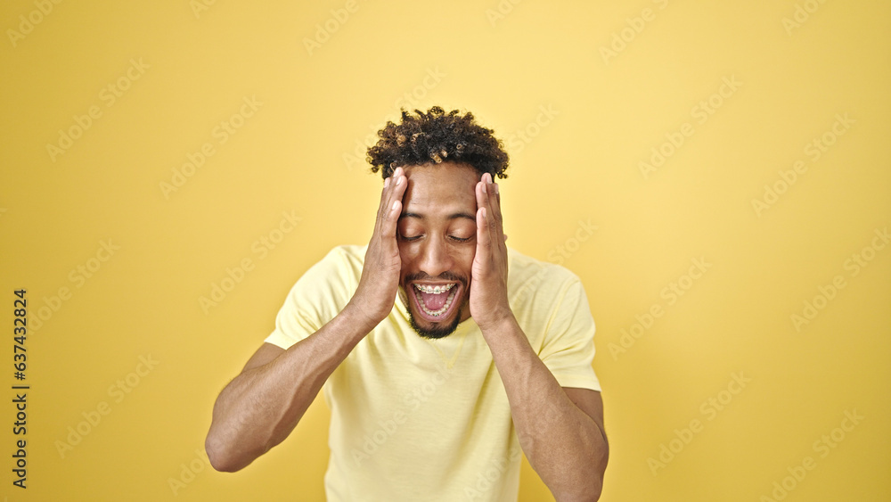 African american man standing with surprise expression over isolated yellow background African american man standing with surprise expression over isolated yellow background